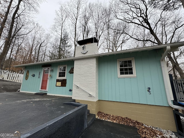 view of front of home featuring a chimney and fence