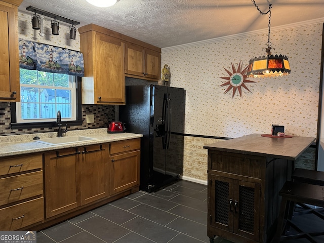 kitchen with wallpapered walls, crown molding, and a sink