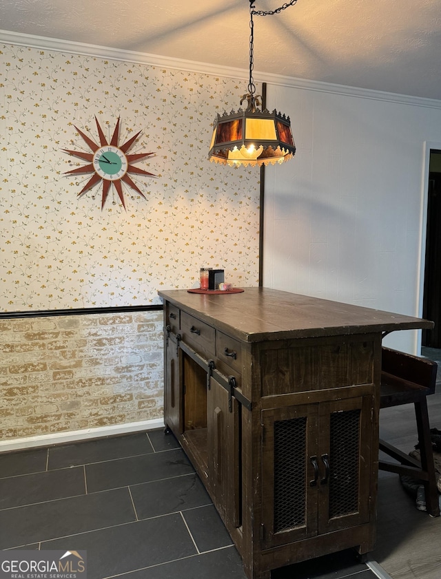 interior space featuring baseboards, dark tile patterned flooring, and crown molding