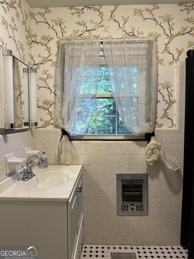 bathroom featuring heating unit, a wainscoted wall, toilet, vanity, and wallpapered walls