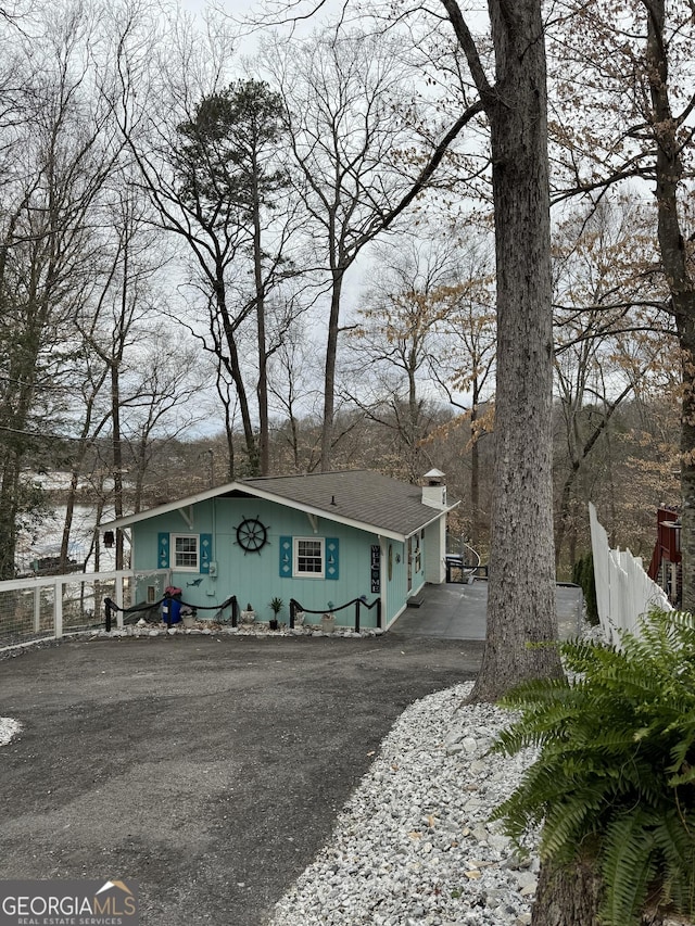 view of front facade with driveway and fence