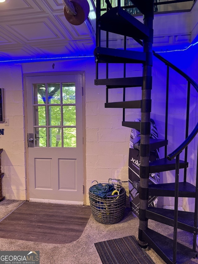 doorway featuring an ornate ceiling, wood finished floors, and concrete block wall