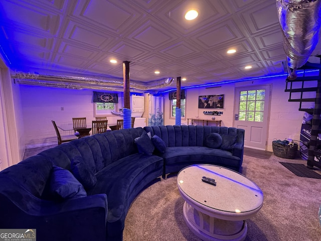 living room with concrete block wall, recessed lighting, and an ornate ceiling