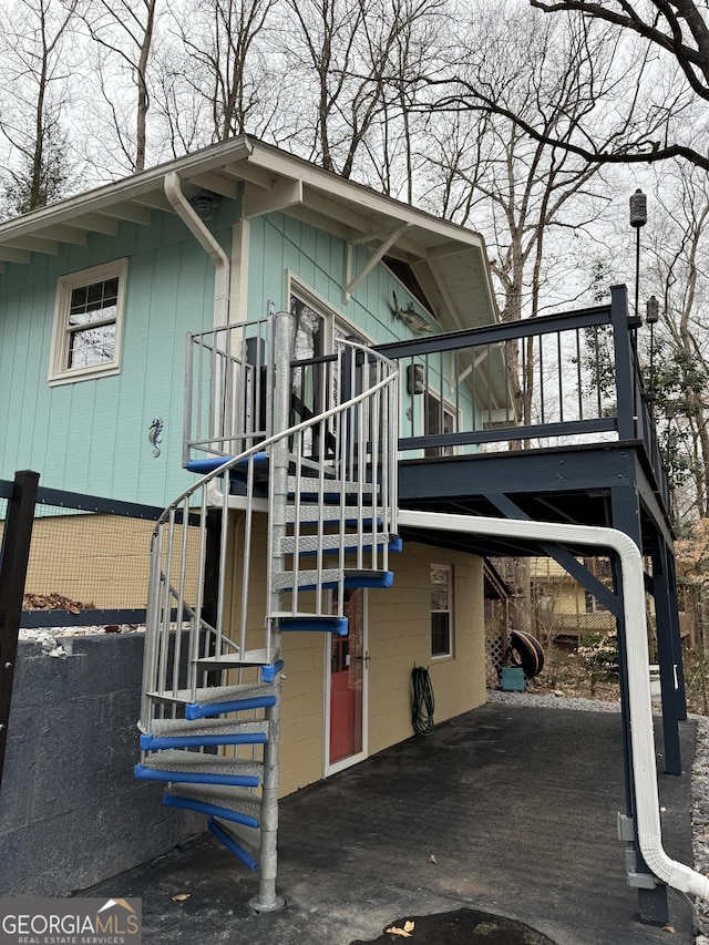 view of side of home with stairway and a wooden deck