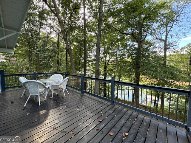 wooden terrace with outdoor dining area and a water view