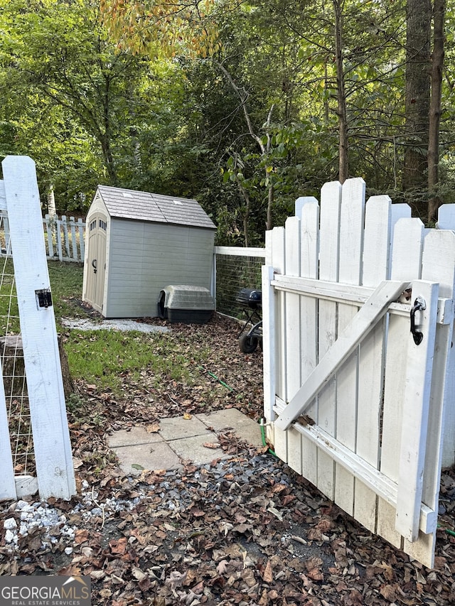 view of yard featuring an outdoor structure, fence, and a storage shed