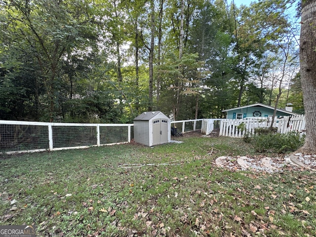 view of yard with an outdoor structure, a fenced backyard, and a shed