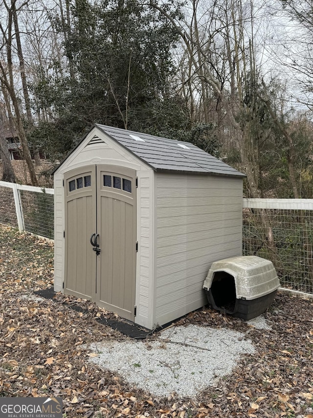view of shed featuring fence