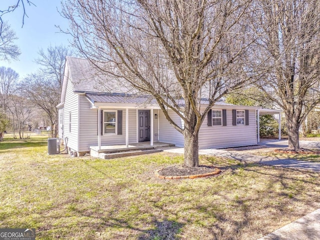 view of front of property featuring a porch, a carport, a front lawn, central air condition unit, and metal roof