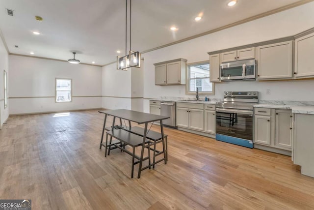 kitchen with a healthy amount of sunlight, visible vents, a sink, gray cabinetry, and stainless steel appliances