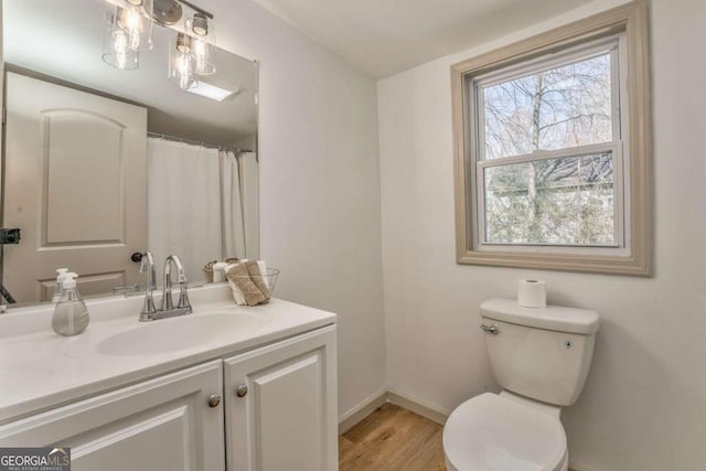 full bath featuring baseboards, toilet, wood finished floors, and vanity