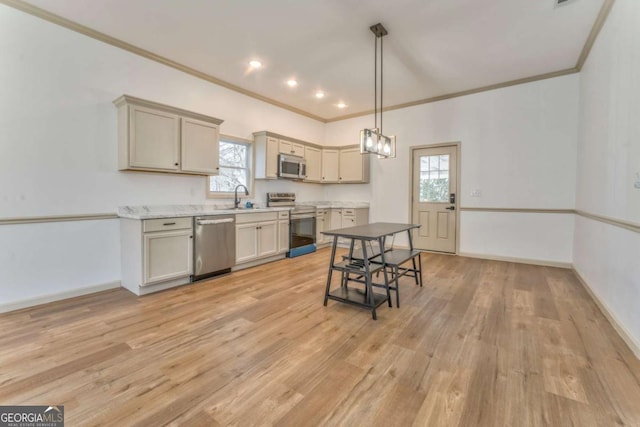 kitchen with light wood finished floors, baseboards, appliances with stainless steel finishes, and a sink