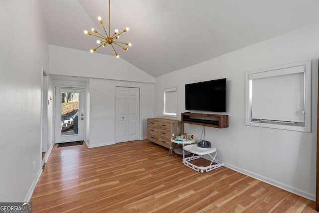 living room with a notable chandelier, light wood-style flooring, baseboards, and lofted ceiling