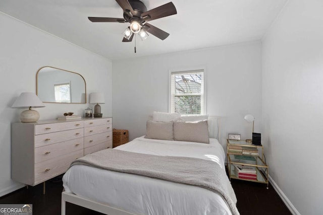 bedroom with dark wood-type flooring, a ceiling fan, and baseboards