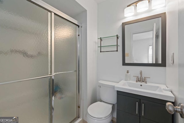 full bathroom with vanity, a shower stall, and toilet