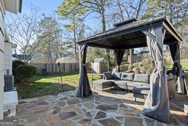 view of patio featuring an outdoor living space, a storage unit, a fenced backyard, and an outdoor structure