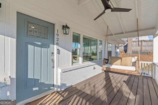 wooden terrace featuring a ceiling fan and fence