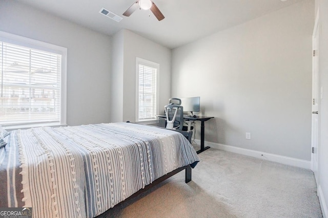 carpeted bedroom featuring baseboards, visible vents, and ceiling fan