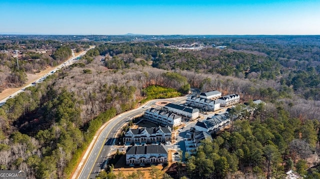 birds eye view of property featuring a wooded view