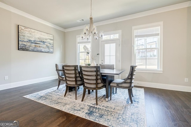 dining area with dark wood finished floors, a notable chandelier, baseboards, and ornamental molding