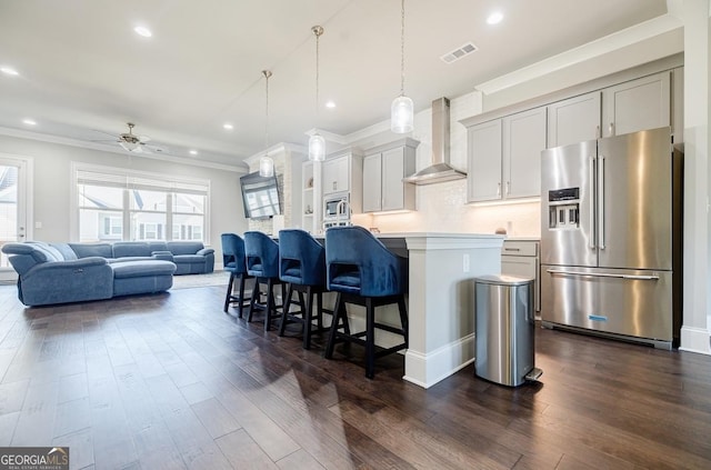 kitchen with wall chimney exhaust hood, visible vents, a wealth of natural light, and stainless steel appliances