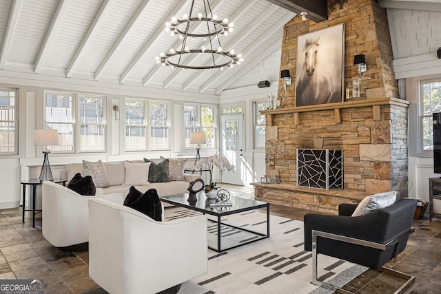 living room with beam ceiling, high vaulted ceiling, stone tile floors, an inviting chandelier, and a fireplace