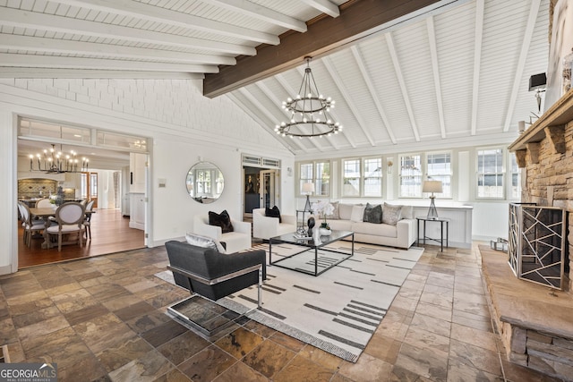 living room featuring stone tile flooring, baseboards, vaulted ceiling with beams, and an inviting chandelier