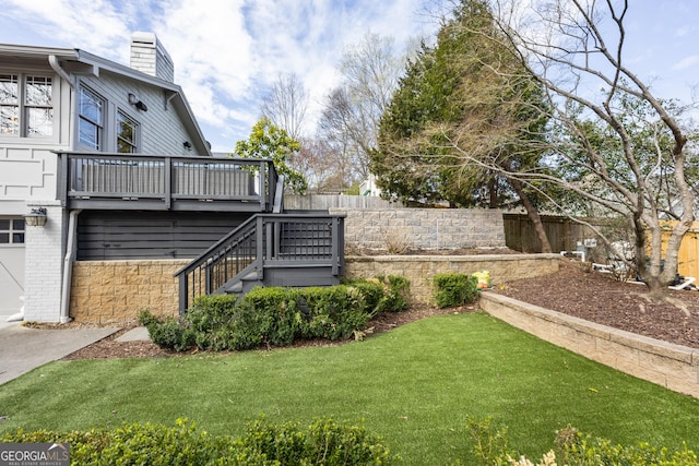 view of yard with stairway, a fenced backyard, and a deck