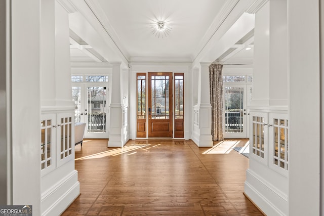 entryway with a decorative wall, a healthy amount of sunlight, french doors, and ornamental molding