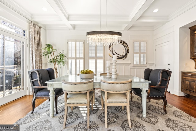 dining space with beamed ceiling, coffered ceiling, and wood finished floors