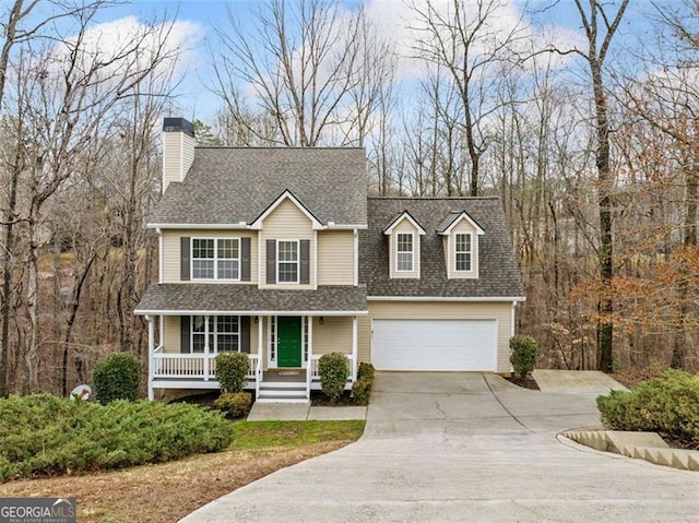 view of front of home featuring a garage, covered porch, driveway, and a shingled roof