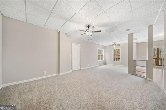 unfurnished room featuring a drop ceiling, ceiling fan, baseboards, and carpet