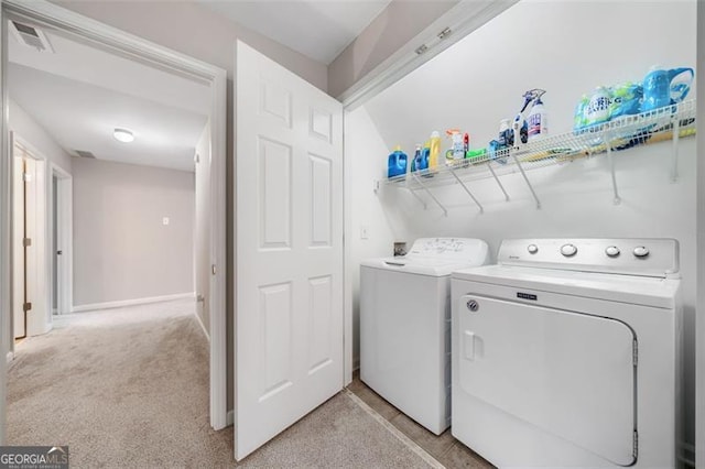 clothes washing area with visible vents, baseboards, light colored carpet, laundry area, and washing machine and clothes dryer