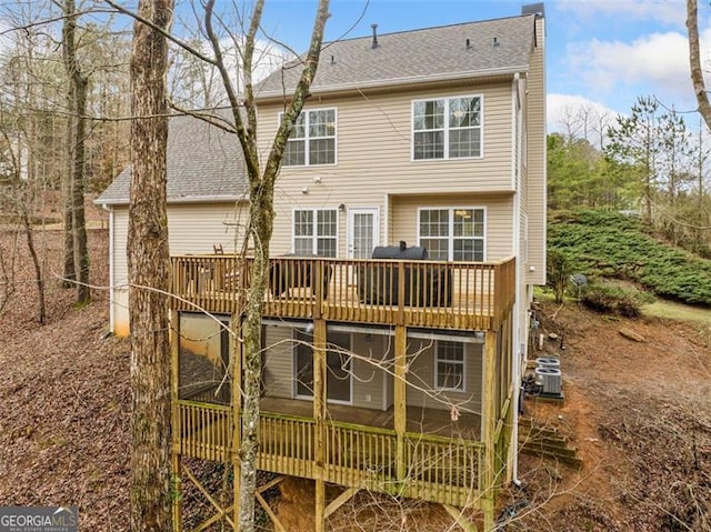 rear view of house with a deck and a shingled roof