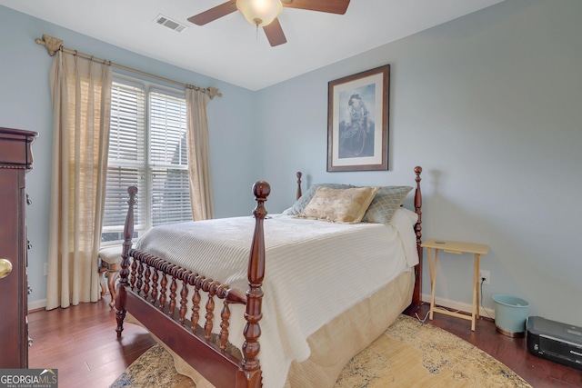 bedroom featuring ceiling fan, wood finished floors, visible vents, and baseboards