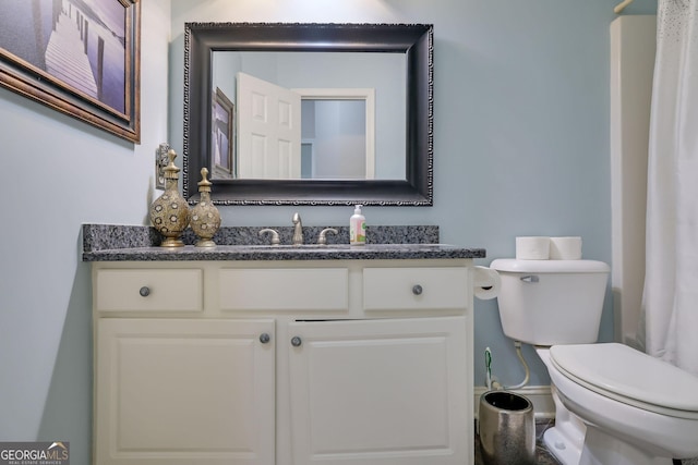 bathroom with vanity, toilet, and baseboards