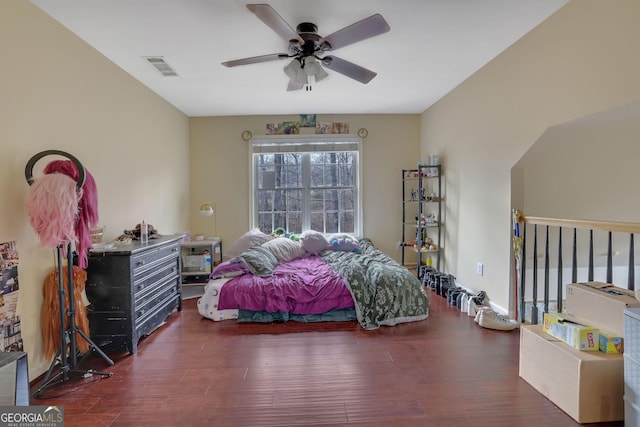 bedroom featuring baseboards, wood finished floors, visible vents, and ceiling fan