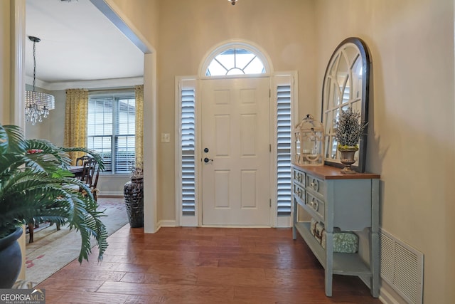 foyer featuring visible vents, baseboards, and dark wood finished floors