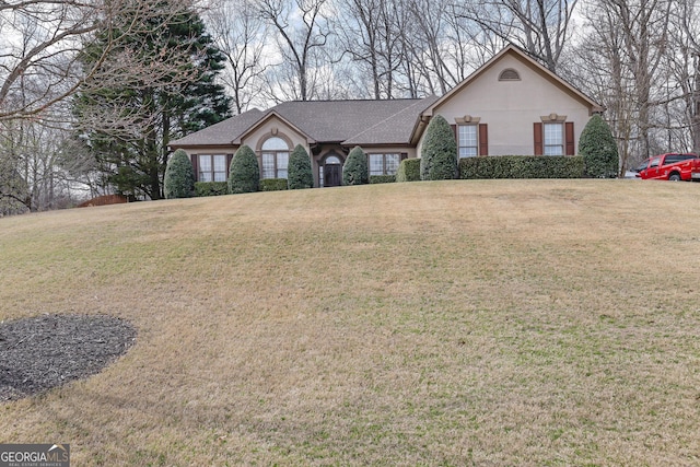 view of front facade featuring stucco siding, roof with shingles, and a front lawn