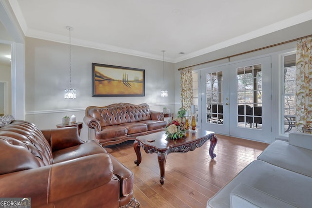 living room with crown molding, visible vents, wood finished floors, and french doors
