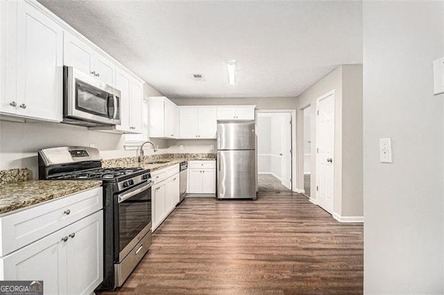 kitchen with a sink, dark wood-type flooring, white cabinets, and stainless steel appliances