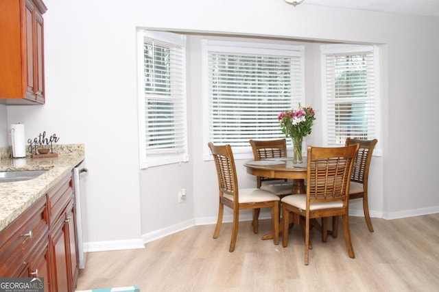 dining space featuring light wood-type flooring and baseboards