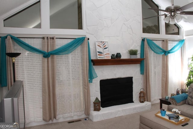 living area with visible vents, a fireplace, a ceiling fan, and carpet floors