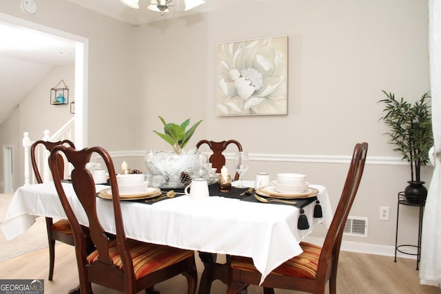 dining space with visible vents, baseboards, and wood finished floors