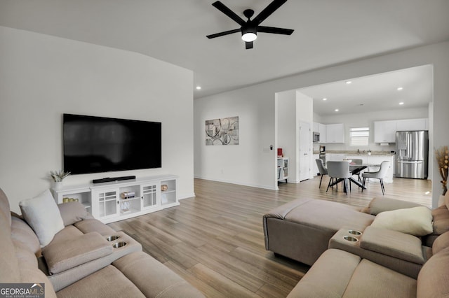 living area featuring recessed lighting, ceiling fan, baseboards, and light wood-style floors