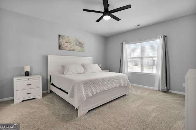 bedroom featuring visible vents, light carpet, baseboards, and ceiling fan