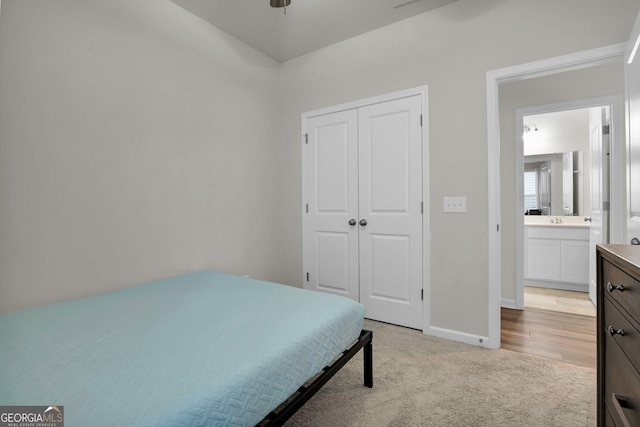 bedroom featuring light carpet, baseboards, and a closet