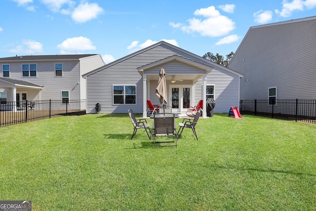 rear view of property with french doors, a lawn, a fenced backyard, and a ceiling fan