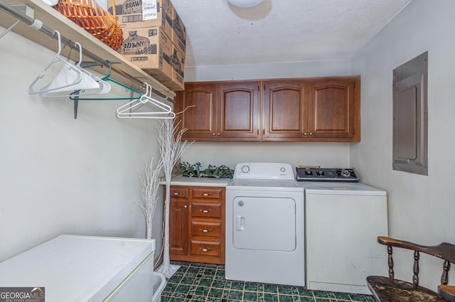 washroom featuring electric panel, cabinet space, separate washer and dryer, and a textured ceiling