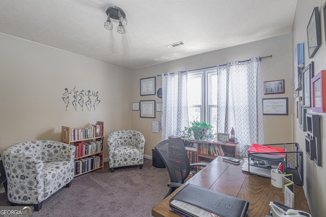 office area with visible vents, carpet floors, a textured ceiling, and baseboards